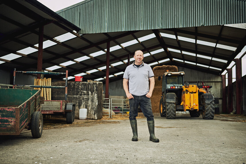 An open gable (drive-through) large machinery shed with a machine inside surrounded by machines.